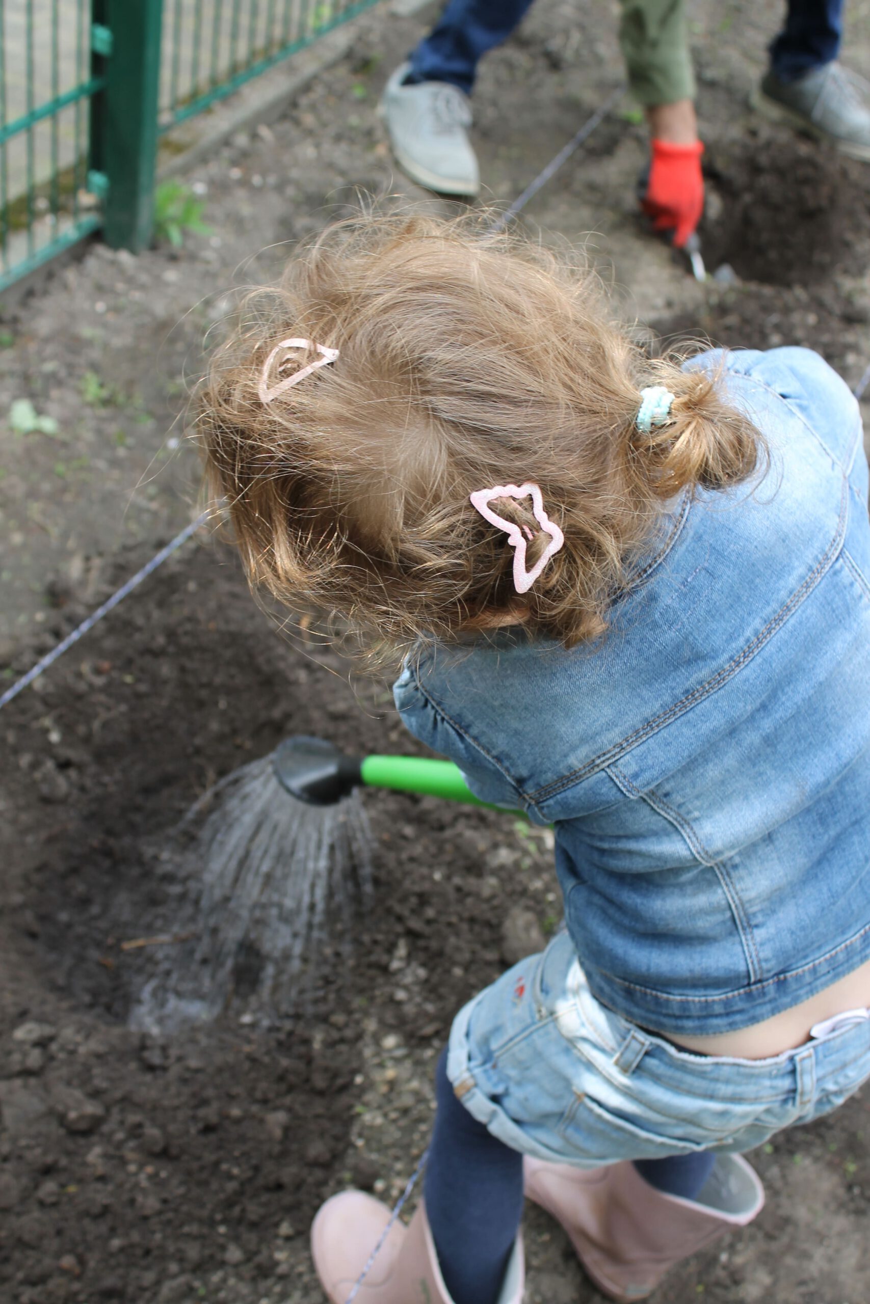 Ein Kind gießt den Acker.
