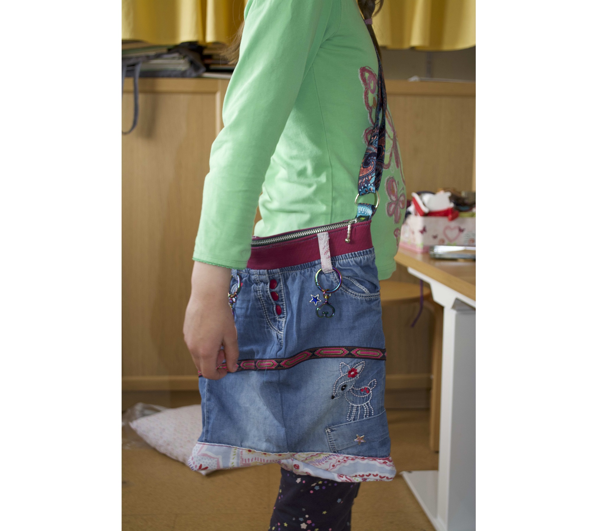 Upcycling: Kind trägt eine Tasche, die aus einer alten Jeans genäht wurde.
