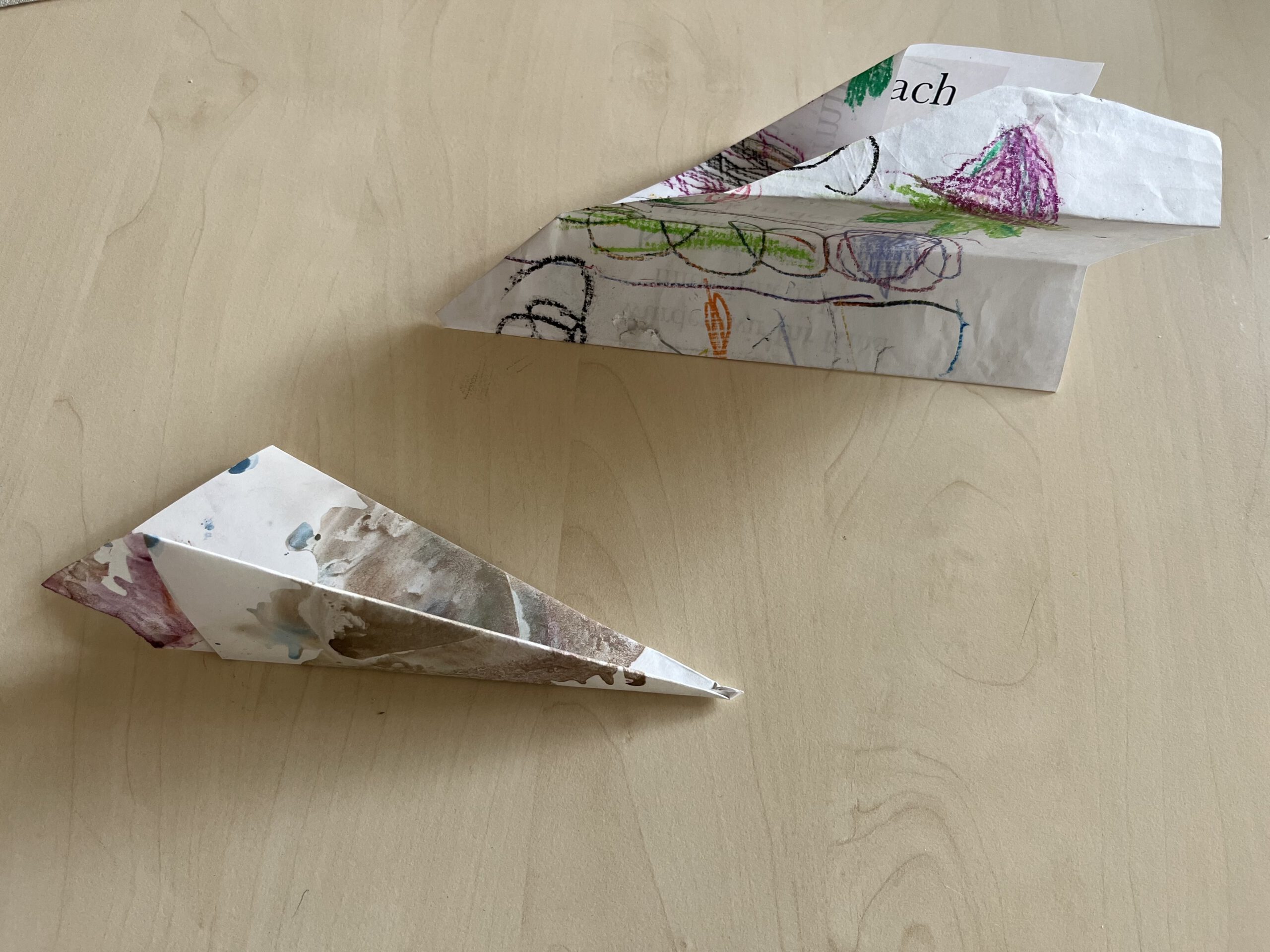 Bemalte Bilder wurden zu Papierfliegern gefaltet.