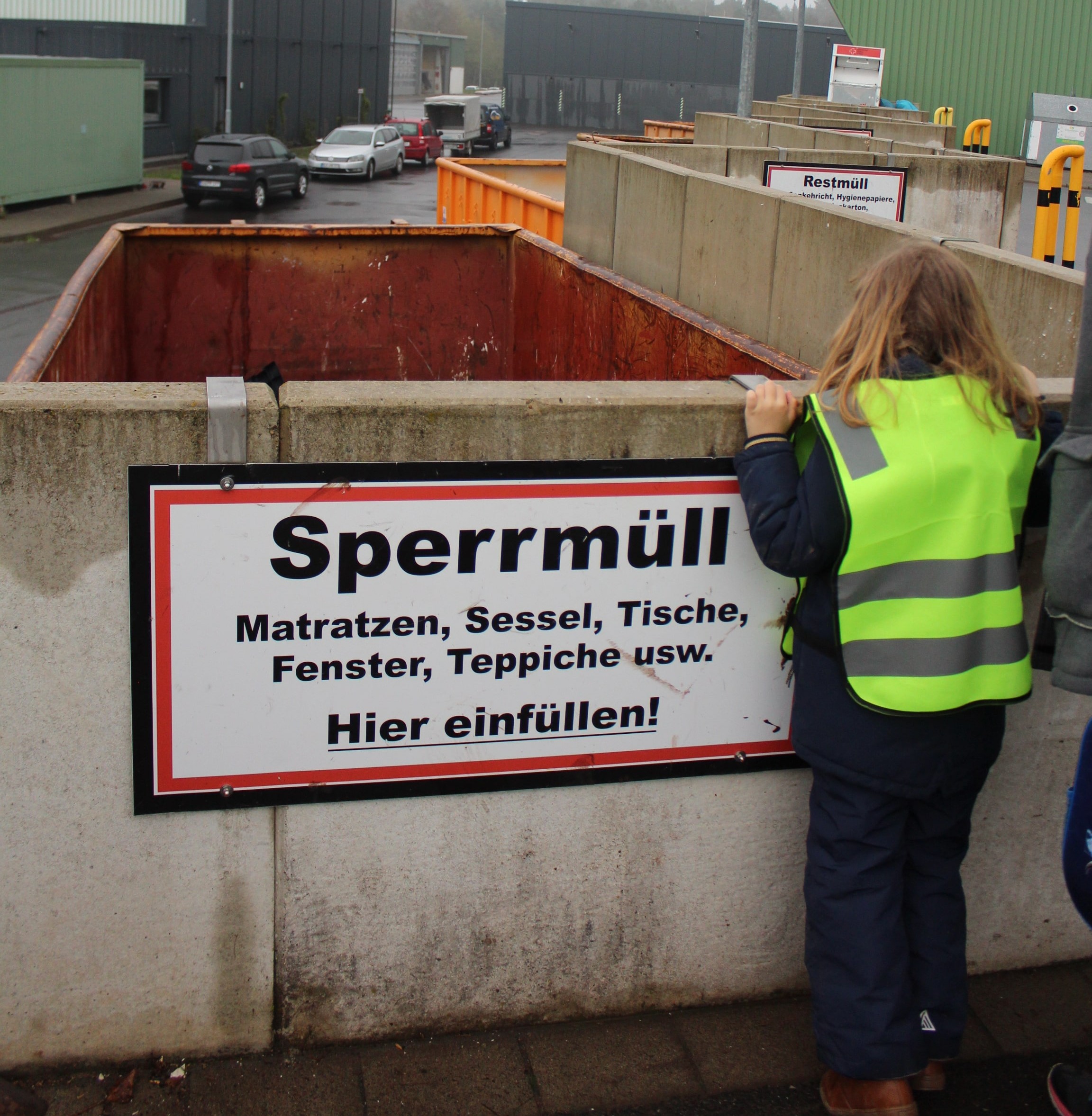 Ein Kind schaut in einen Sperrmüll-Container bei der Abfallverwertung.